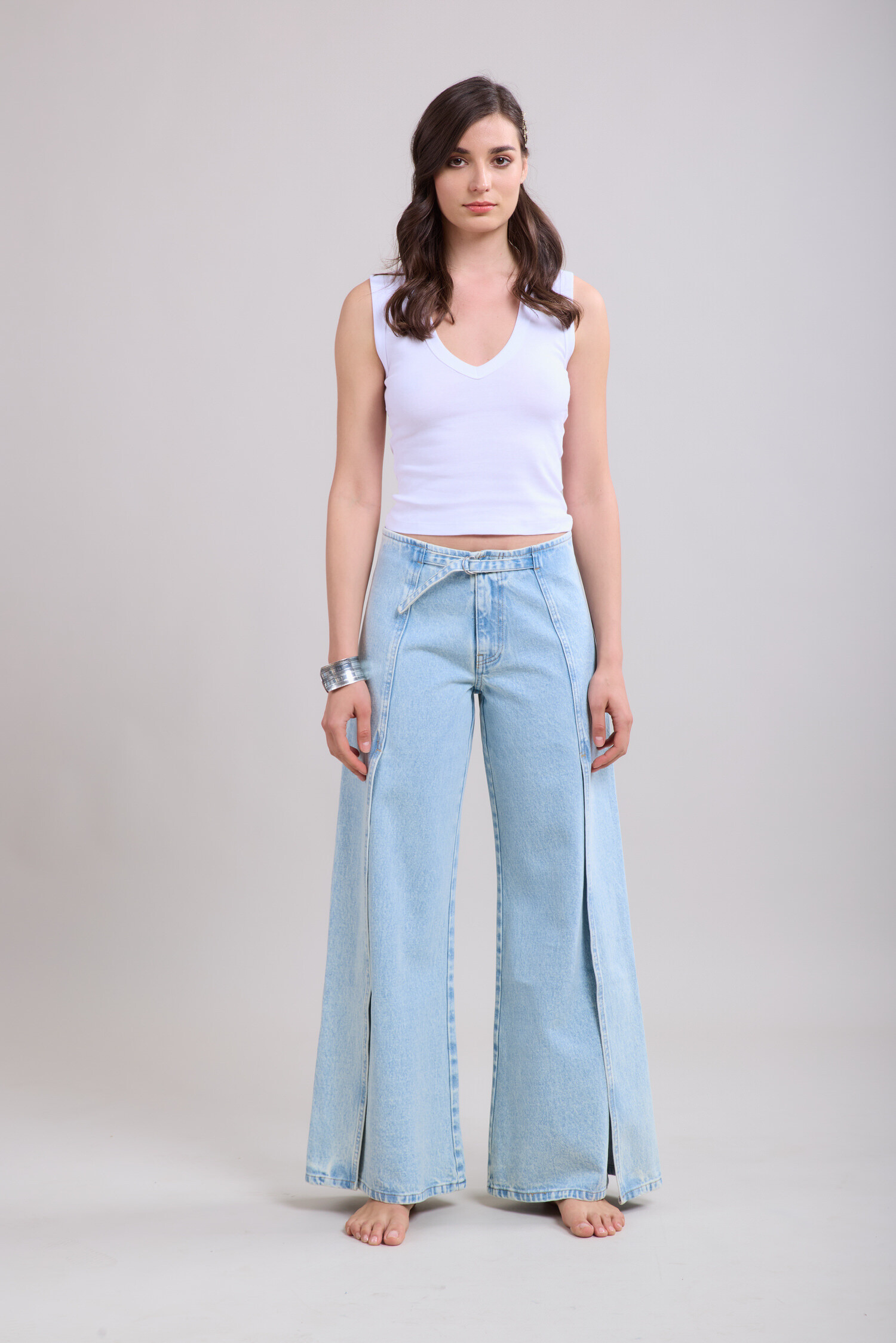 Un jean évasé moderne, agrémenté de fentes discrètes pour une silhouette allongée et un style tendance.