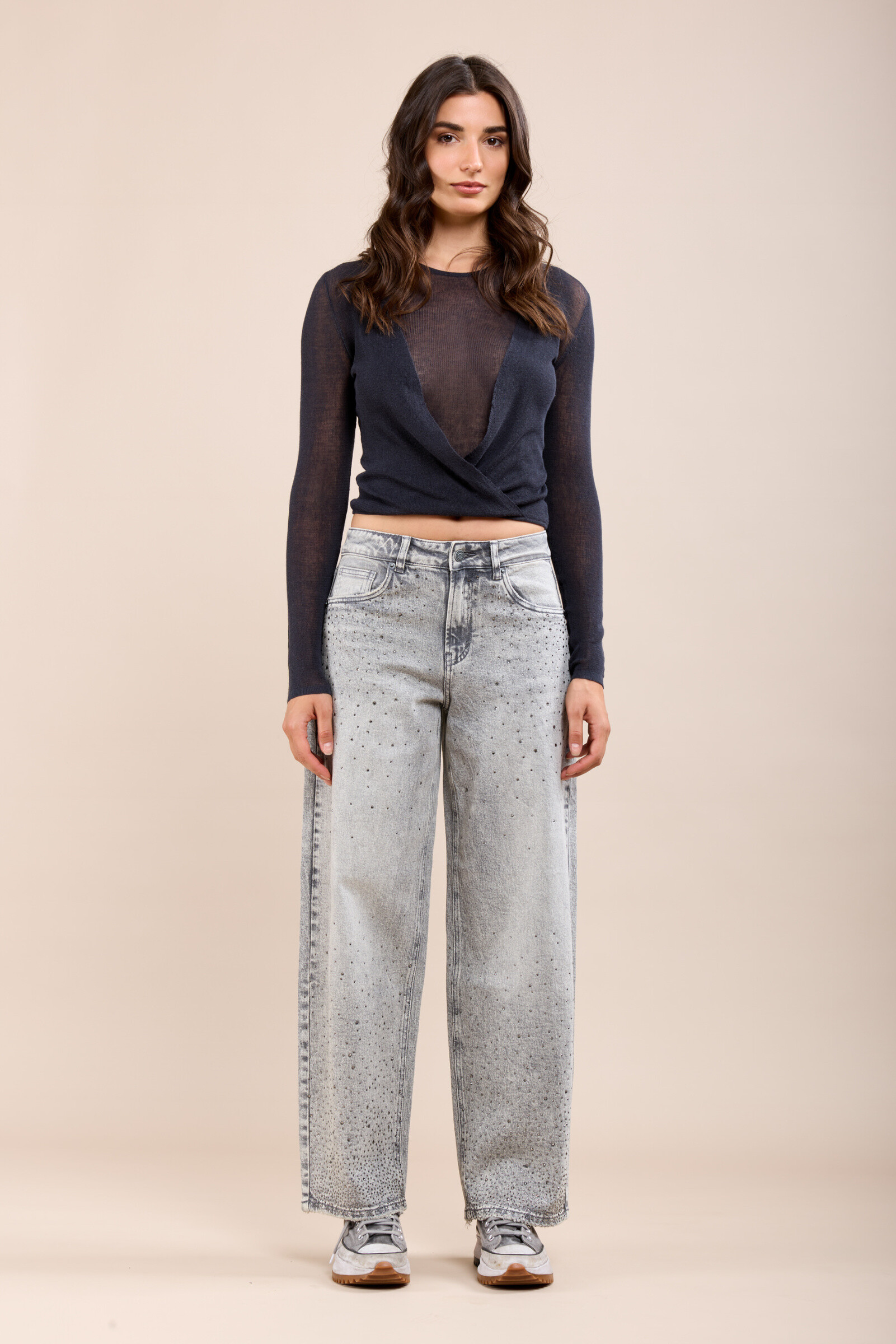 Ce jean confectionné dans un tissu stretch confortable propose une coupe ballon et une fermeture par zip. Il se distingue par ses cristaux strass ton sur ton sur l'avant du jean.