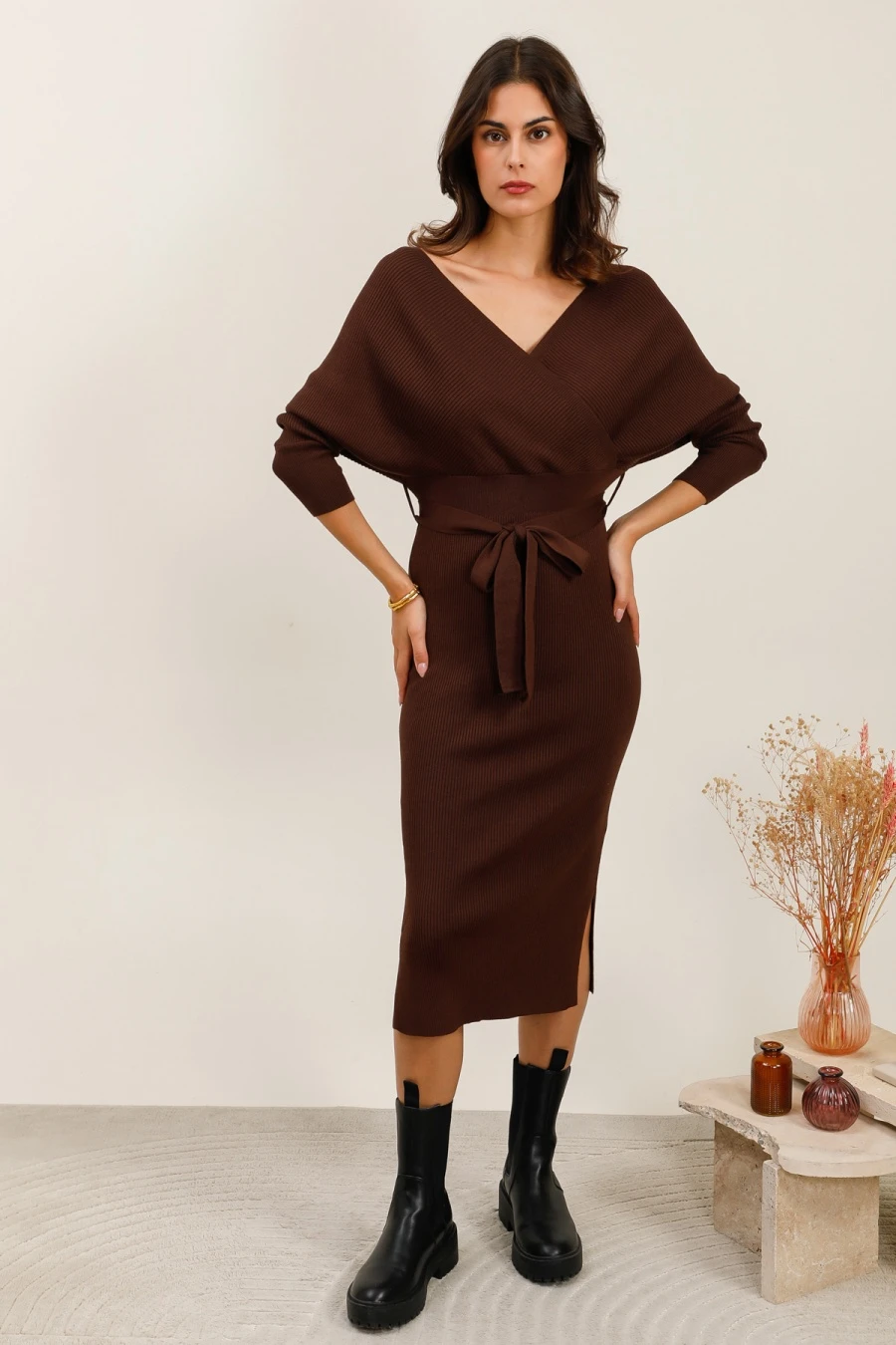 Robe en maille côtelée longueur midi avec décolleté cache-cœur croisé et manches longues. Sa ceinture à nouer à la taille permet d’ajuster la silhouette et de souligner les formes. La coupe ajustée est accompagnée de petites fentes latérales pour plus de confort et de féminité. Un modèle élégant et polyvalent, idéal pour la mi-saison et l’hiver.