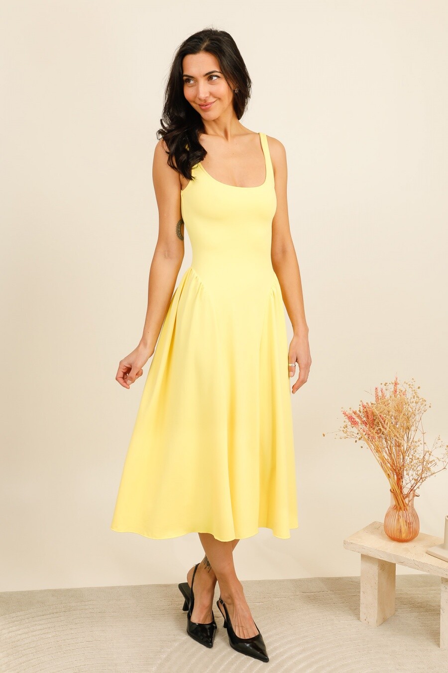 Cette robe longue se distingue par sa ligne fluide et sa coupe féminine, mettant en valeur la silhouette tout en offrant un confort optimal. L’encolure carrée moderne structure le haut de la pièce, tandis que le dos dégagé apporte une touche élégante et raffinée. La jupe ample légèrement froncée à la taille crée un joli volume et accompagne le mouvement avec légèreté, idéale pour la saison estivale ou des looks casual chic.