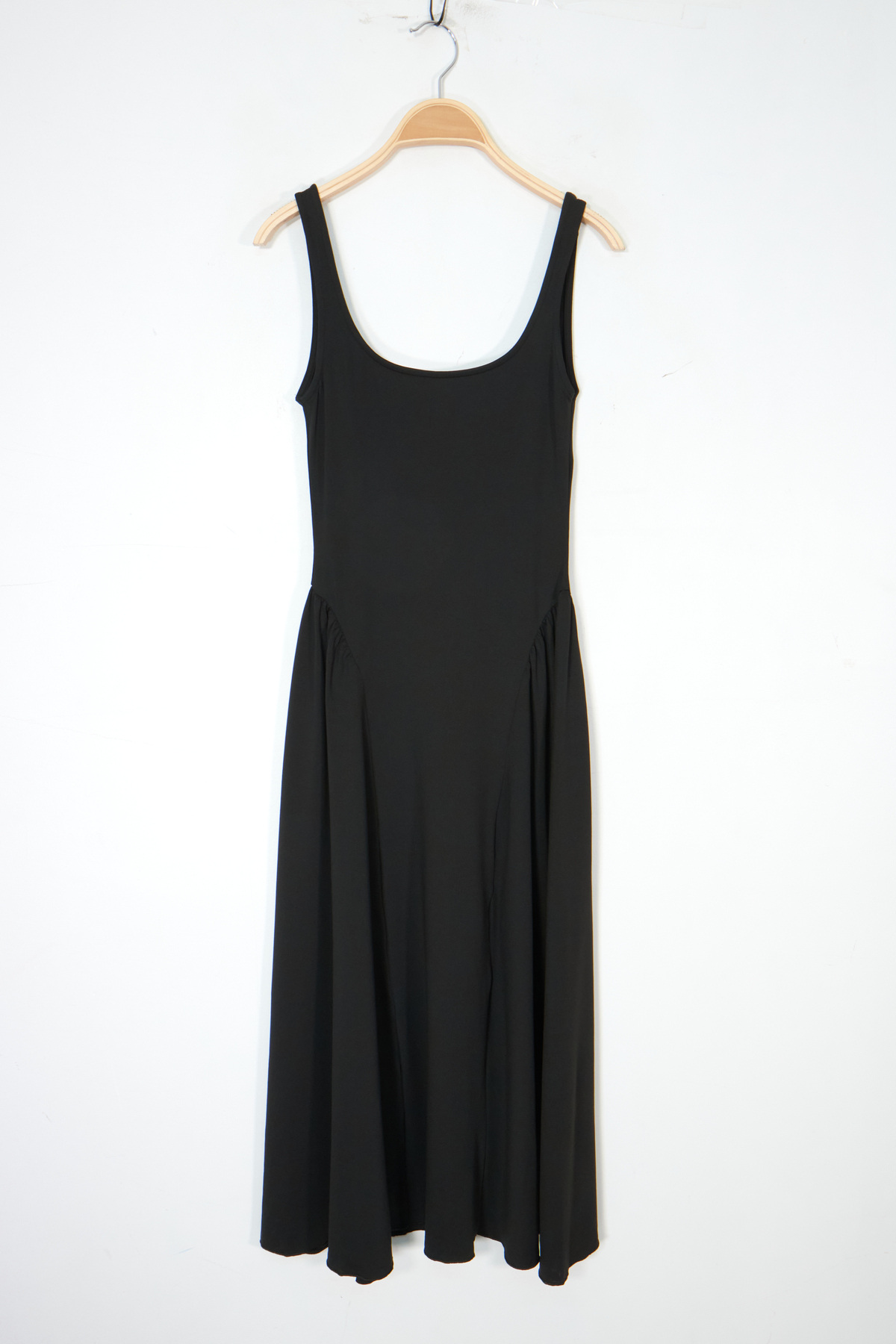 This long dress stands out with its fluid line and feminine cut, enhancing the silhouette while providing optimal comfort. The modern square neckline structures the top, while the open back adds an elegant and refined touch. The full skirt, slightly gathered at the waist, creates a lovely volume and moves gracefully, perfect for the summer season or casual chic looks.
